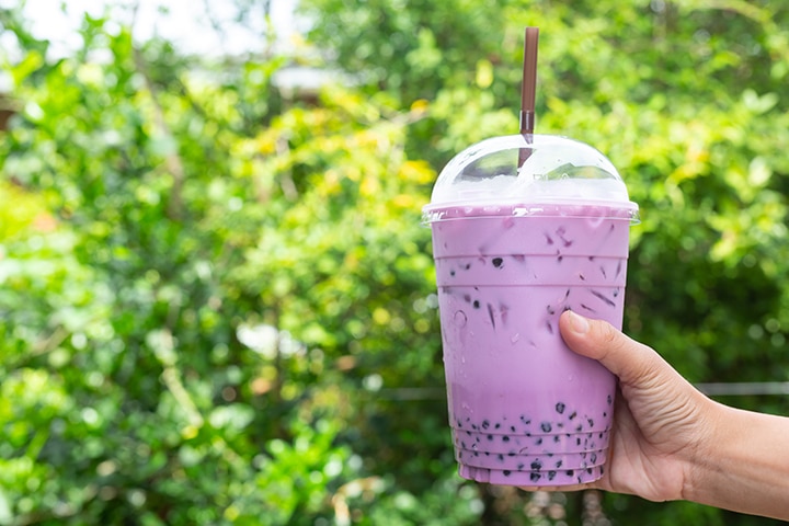 Girl holding a cup of Taro bubble tea