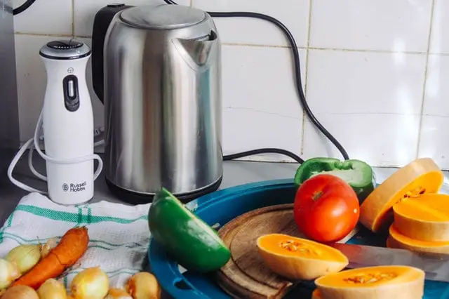 grey metal tea kettle placed in the kitchen