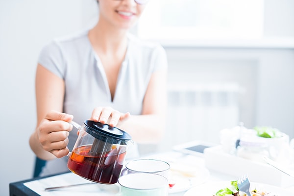 Pouring tea from a glass tea kettle