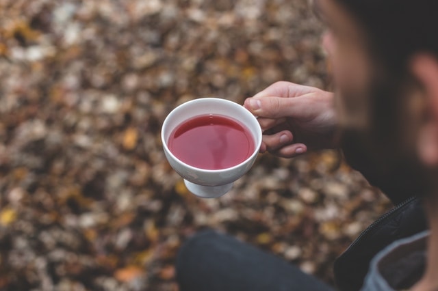 Person holding cup of black tea