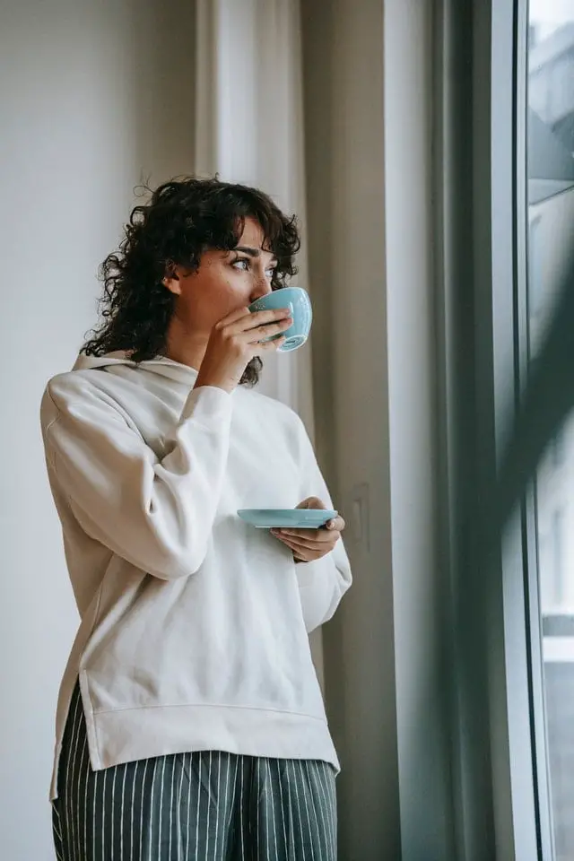 Lady drinking tea near the window