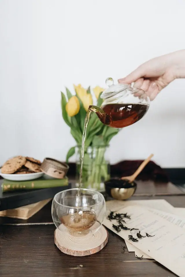 Woman pouring tea from glass tea pot