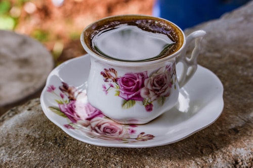 Hot tea poured to purple rose print tea set