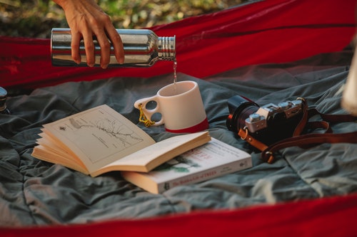 Pouring tea from thermos during picnic