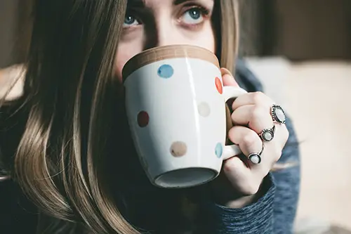 a woman having a mug of tea