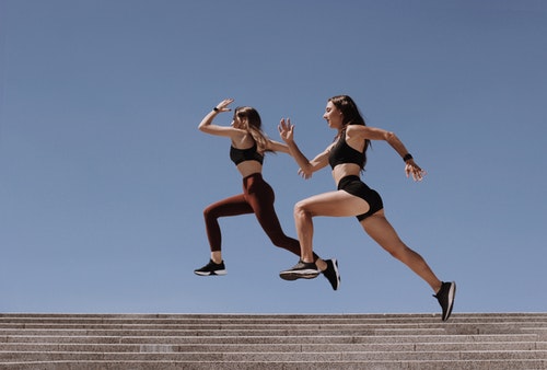 Two Women Jumping Over The Staircase