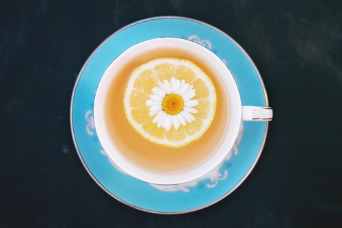 White Flower and Piece of Orange Dipped into Tea