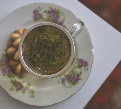 White and Pink Floral Ceramic Cup Filled With Green Tea