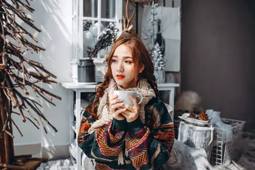 Woman In Multi Color Coat Holding White Mug