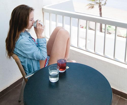 Woman Wearing Blue Shirt Drinking Tea