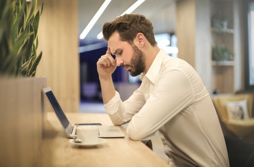 man with a headache caused by excess caffeine