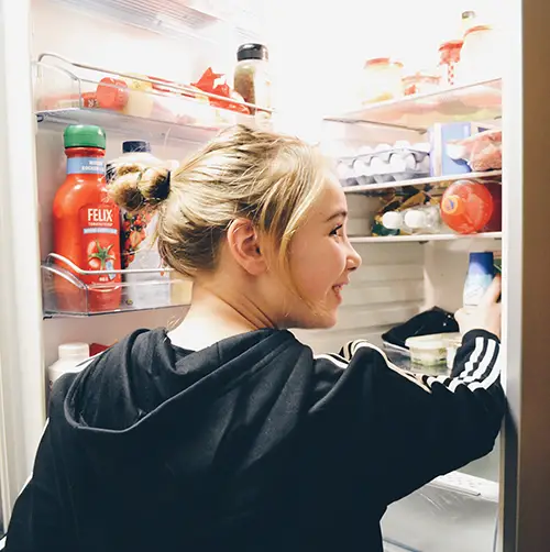 girl checking inside the fridge