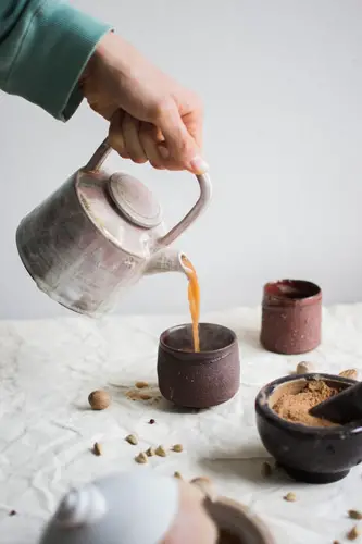 Person pouring hot tea from the kettle