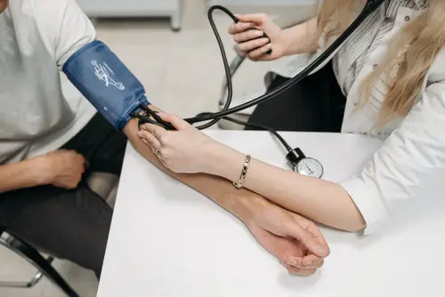 healthcare worker measuring a patient's blood pressure