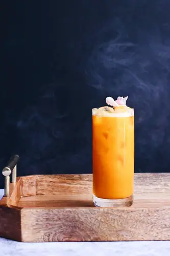 Delicious orange cocktail on wooden tray