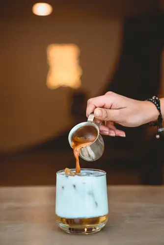 Pouring Espresso On Glass With Milk