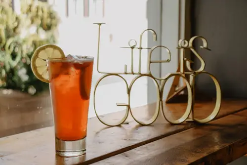 Glass of drink beside Life is GOOD decorative letters board